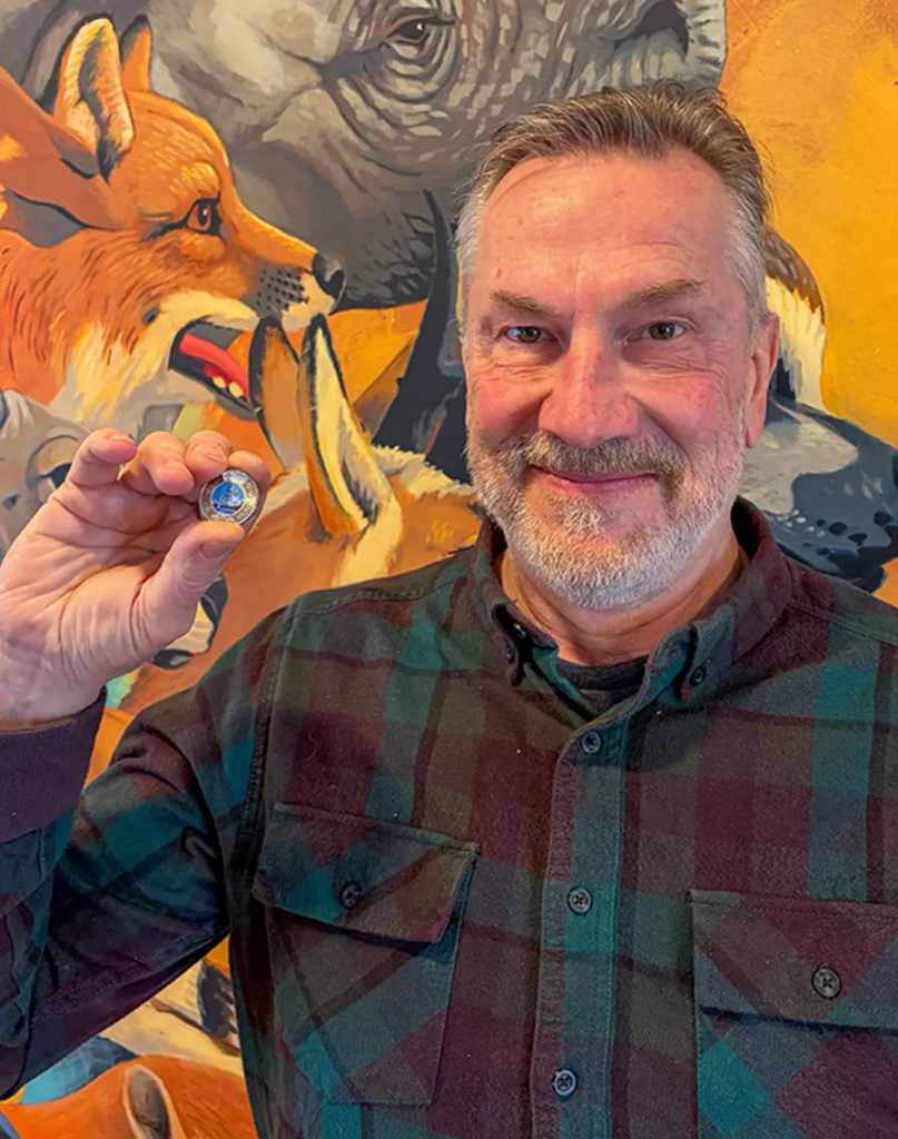 Artist Carl Wiens with commemorative toonie